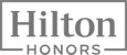The image shows the "Hilton Honors" logo in a black and white design.